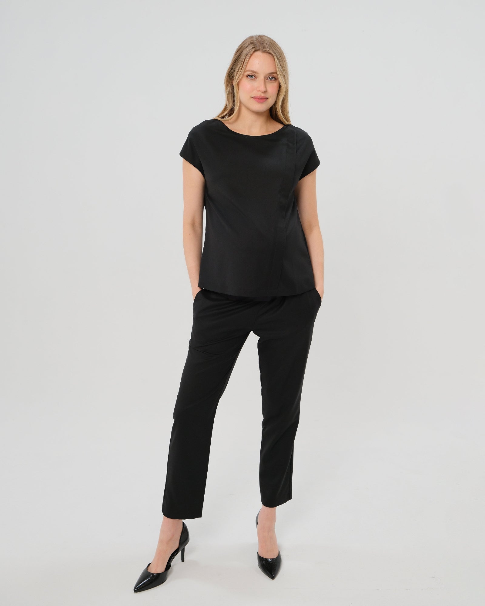 Black maternity dress pants, under belly style, cut in all-season wool blend with hidden flexible waist adjustment, deep pockets, and stylish straight leg. Maternity trousers cropped for tall mamas and full length for petite pregnant women. Postpartum friendly women's wear for business, wedding guest, dinner, and occasion.