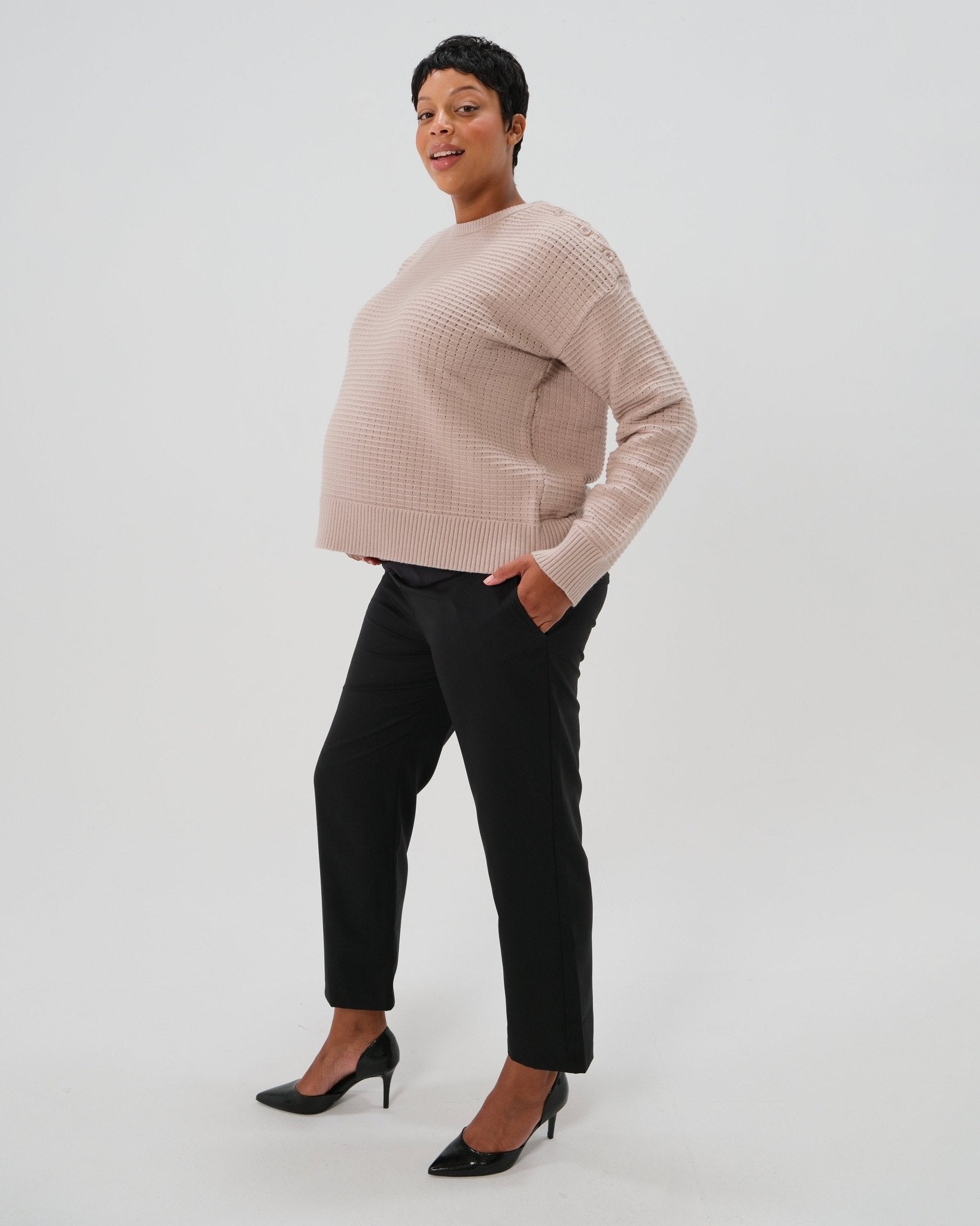 Black plus size maternity dress pants, under belly style, cut in all-season wool blend with hidden flexible waist adjustment, deep pockets, and stylish straight leg. Maternity trousers cropped for tall mamas and full length for petite pregnant women. Postpartum friendly women's wear for business, wedding guest, dinner, and occasion.