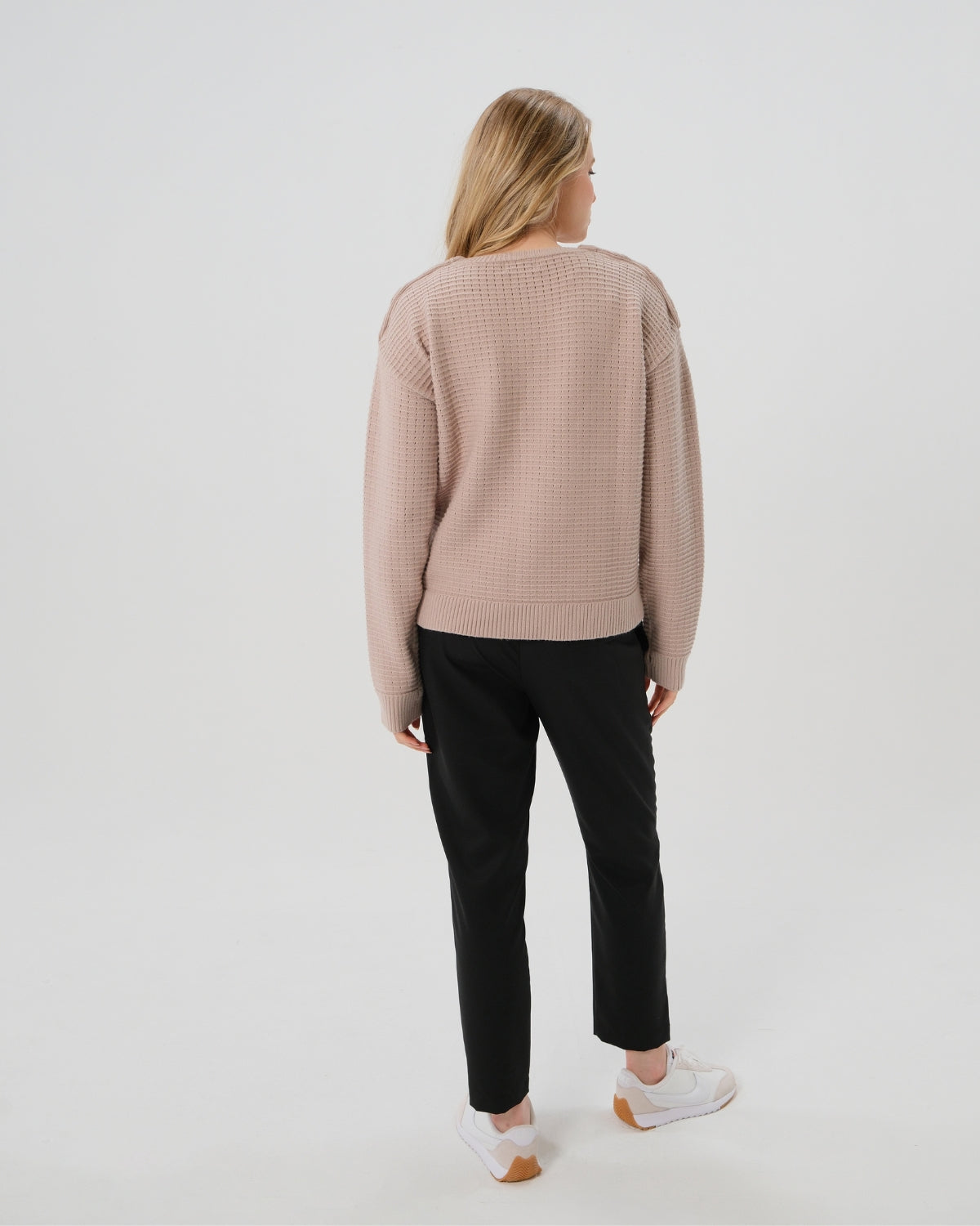 Taupe neutral premium maternity and nursing sweater in stretch cotton box knit. Featuring shoulder button detail for breastfeeding and discreet hem thumbholes for an extra cozy fit. Oversized fit is flattering, polished, and versatile - transitioning from pregnancy workwear to loungewear to streetwear with ease. Petite and tall friendly; available in regular and plus size. Back view.