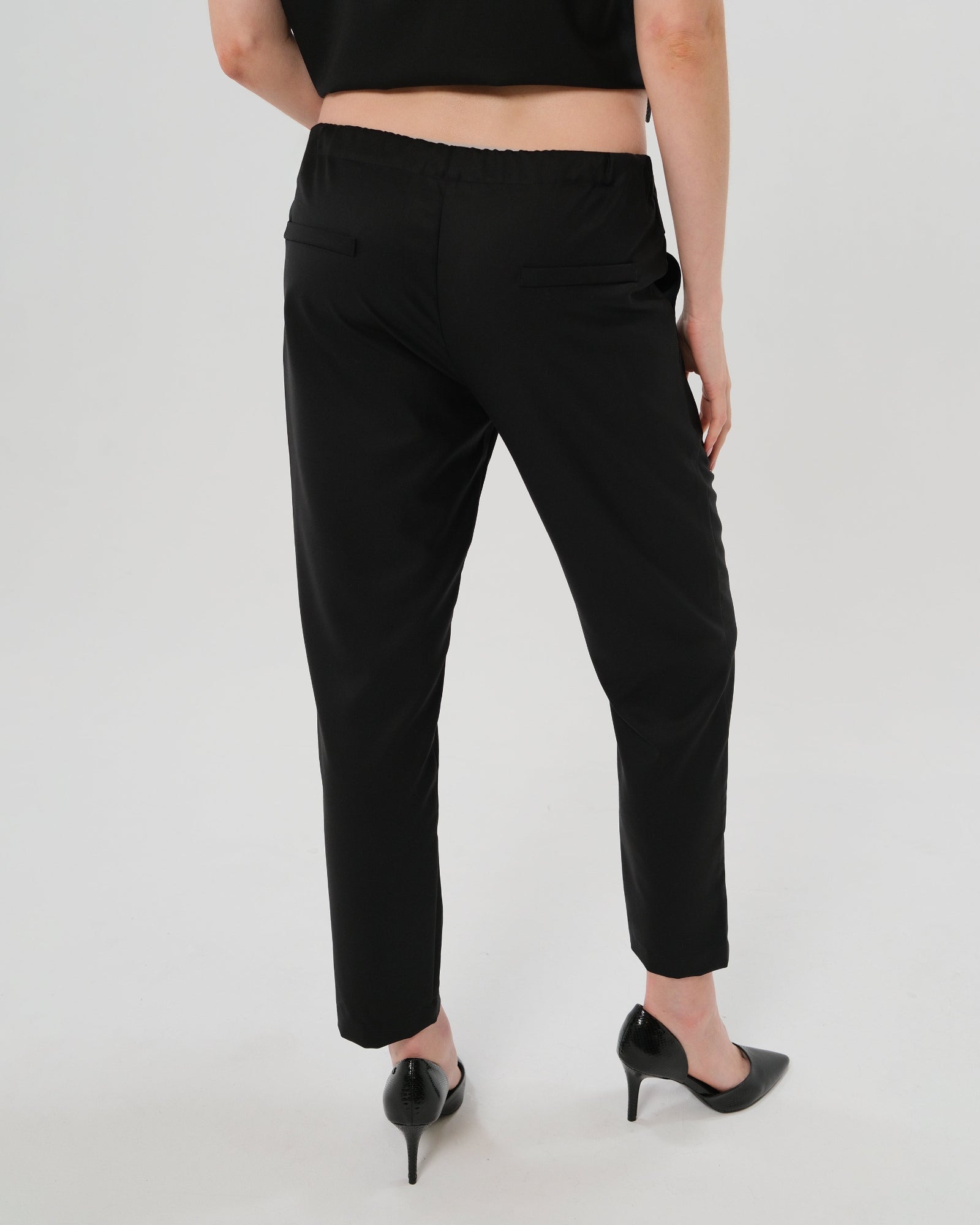 Black maternity dress pants, under belly style, cut in all-season wool blend with hidden flexible waist adjustment, deep pockets, and stylish straight leg. Maternity trousers cropped for tall mamas and full length for petite pregnant women. Postpartum friendly women's wear for business, wedding guest, dinner, and occasion.