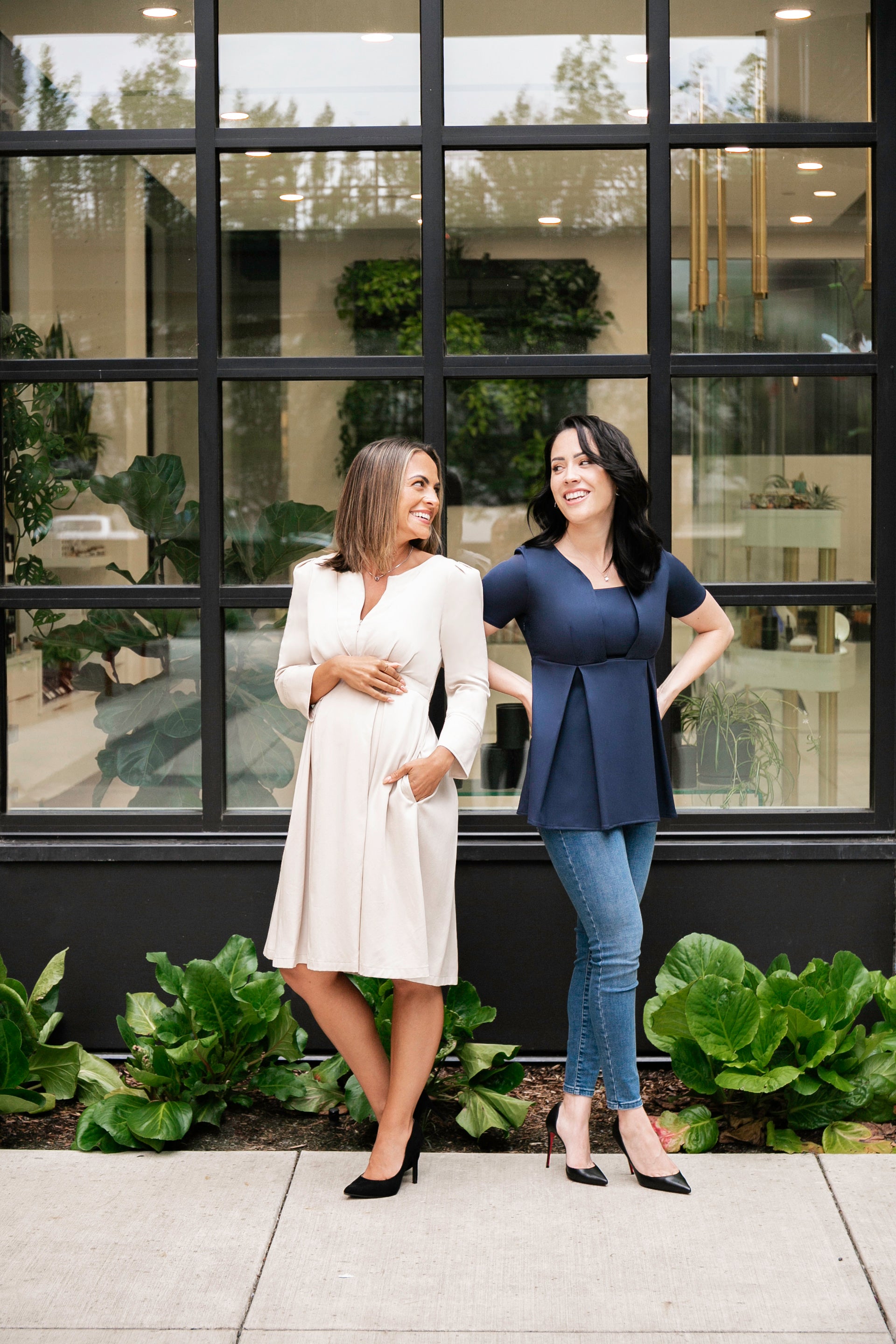 MARION maternity workwear - models showing the luxury beige TENCEL Sarah Maternity and Breastfeeding dress and the sustainable and luxurious Sloan Maternity and Nursing Suit top.  