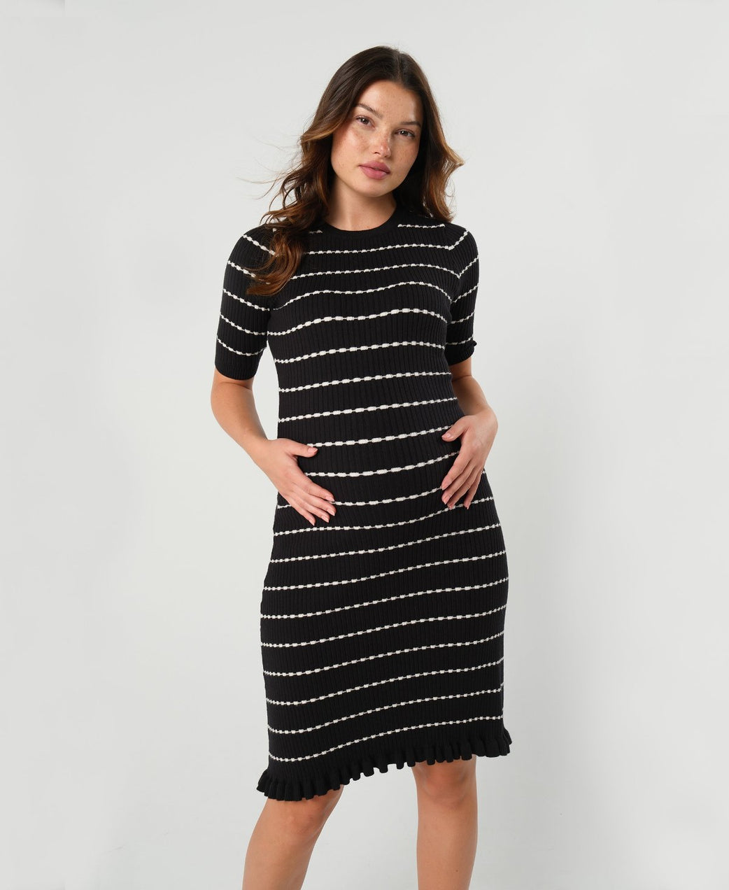 Striped knit maternity and nursing dress in black and white. Knee length three quarter sleeves with feminine hem detail. Ideal for maternity business workwear, date, church, wedding guest, brunch, and occasion. MARION luxury maternity workwear.