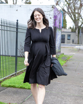 Black maternity and nursing empire dress for business, baby shower, wedding guest, party, and formal occasions. Sustainable TENCEL, zipper breastfeeding access, and full skirt with deep pockets. MARION offers the market's best maternity dresses in petite and standard sizes.