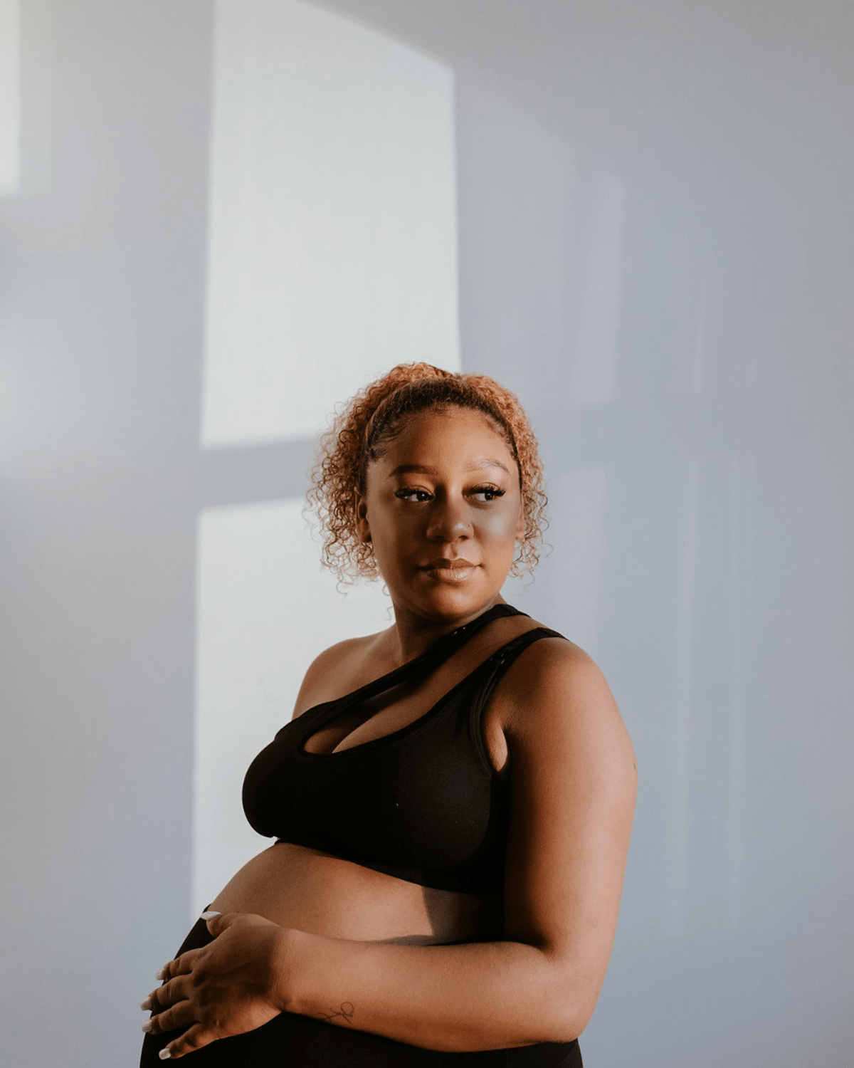 Black one-shoulder maternity and nursing sports bra and athleisure top. Luxe nylon fabric with one hand breastfeeding release clips. 