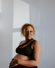 Black one-shoulder maternity and nursing sports bra and athleisure top. Luxe nylon fabric with one hand breastfeeding release clips. 