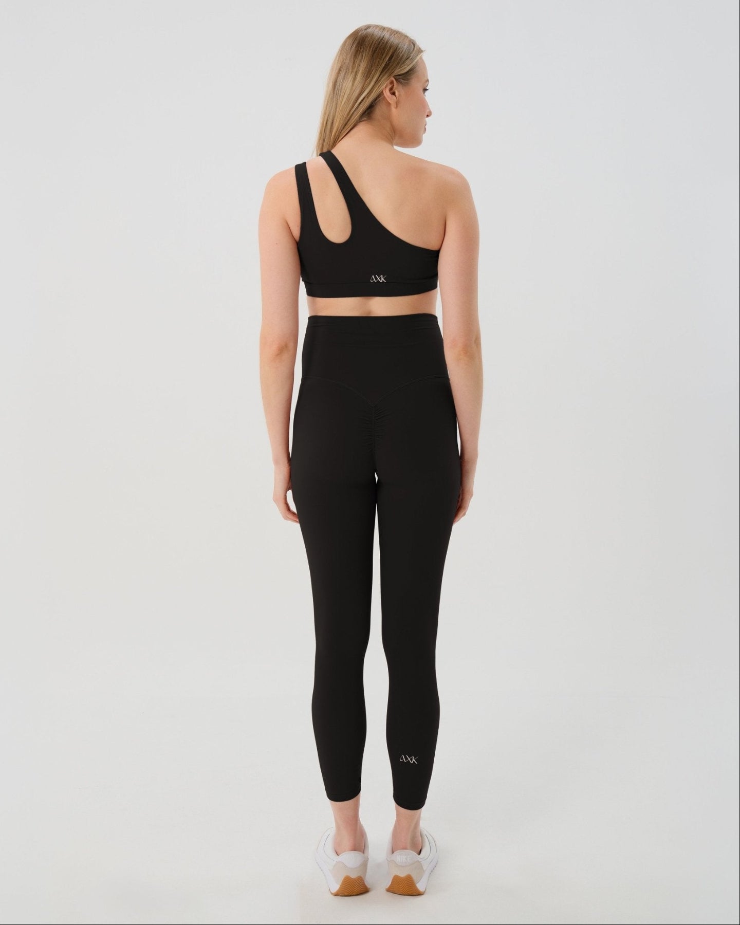 Pregnant woman wearing premium black AXK maternity leggings with flattering scrunch butt and matching high-impact, racerback nursing sports bra. Best reviewed high quality maternity athletic and activewear for 2026, perfect for running, pregnancy yoga, walking, and loungewear. Available in standard and plus sizes, petite and tall friendly. 