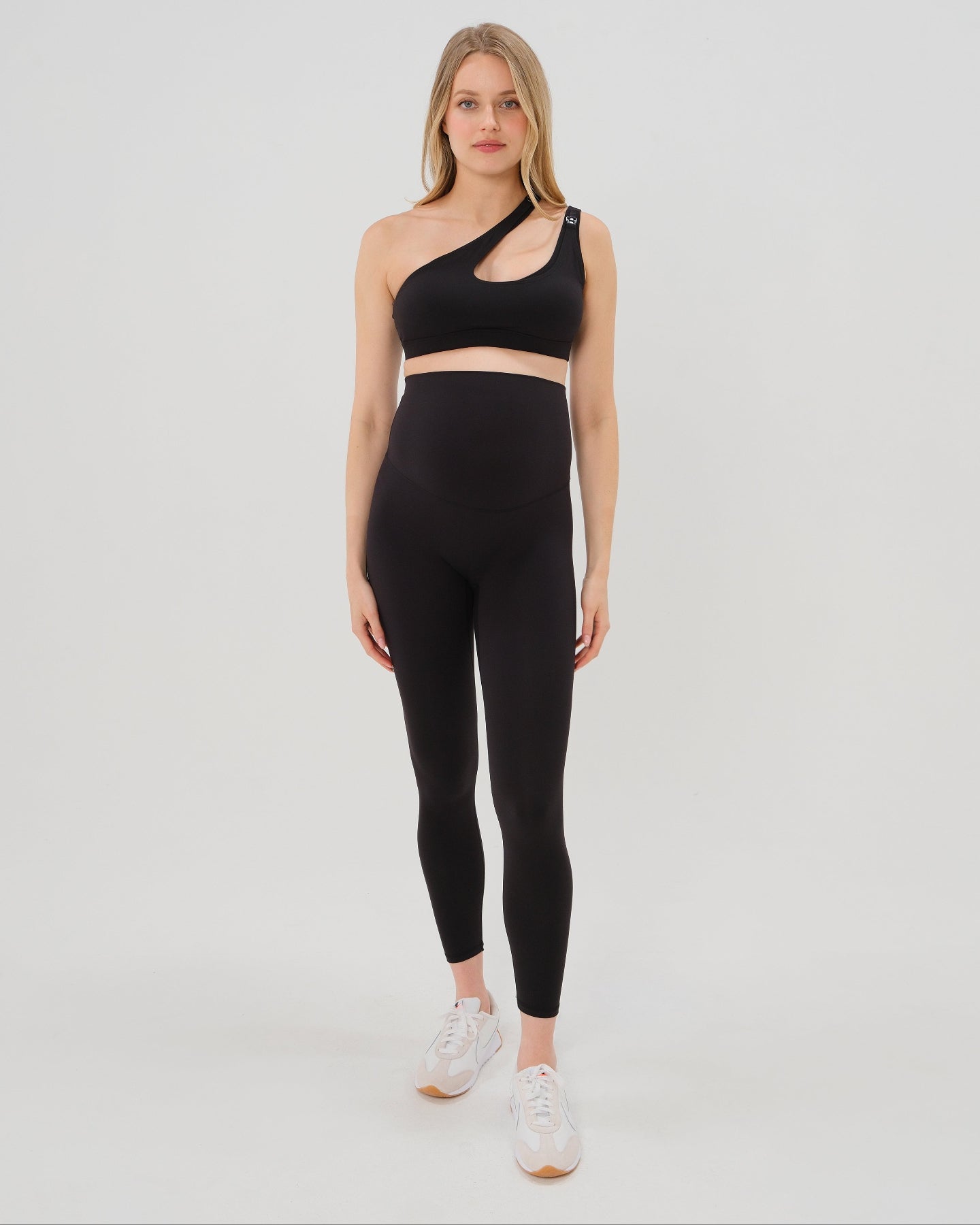 Pregnant woman wearing premium black AXK maternity leggings with flattering scrunch butt and matching high-impact, racerback nursing sports bra. Best reviewed high quality maternity athletic and activewear for 2026, perfect for running, pregnancy yoga, walking, and loungewear. Available in standard and plus sizes, petite and tall friendly. 