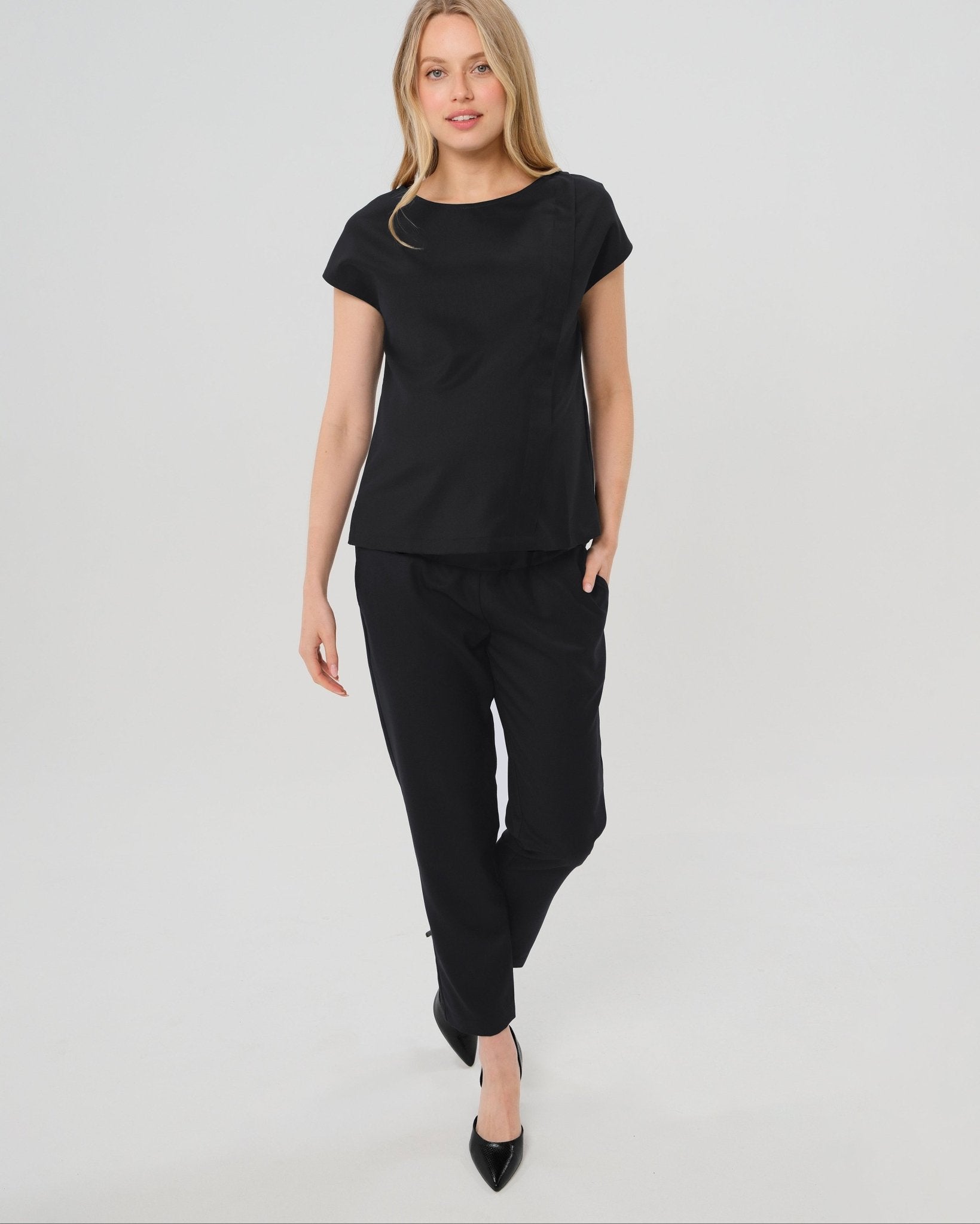 Black maternity pants, under belly style, cut in all-season wool blend with hidden flexible waist adjustment, deep pockets, and stylish straight leg. Maternity trousers cropped for tall mamas and full length for petite pregnant women. Postpartum friendly women's wear for business, wedding guest, dinner, and occasion.