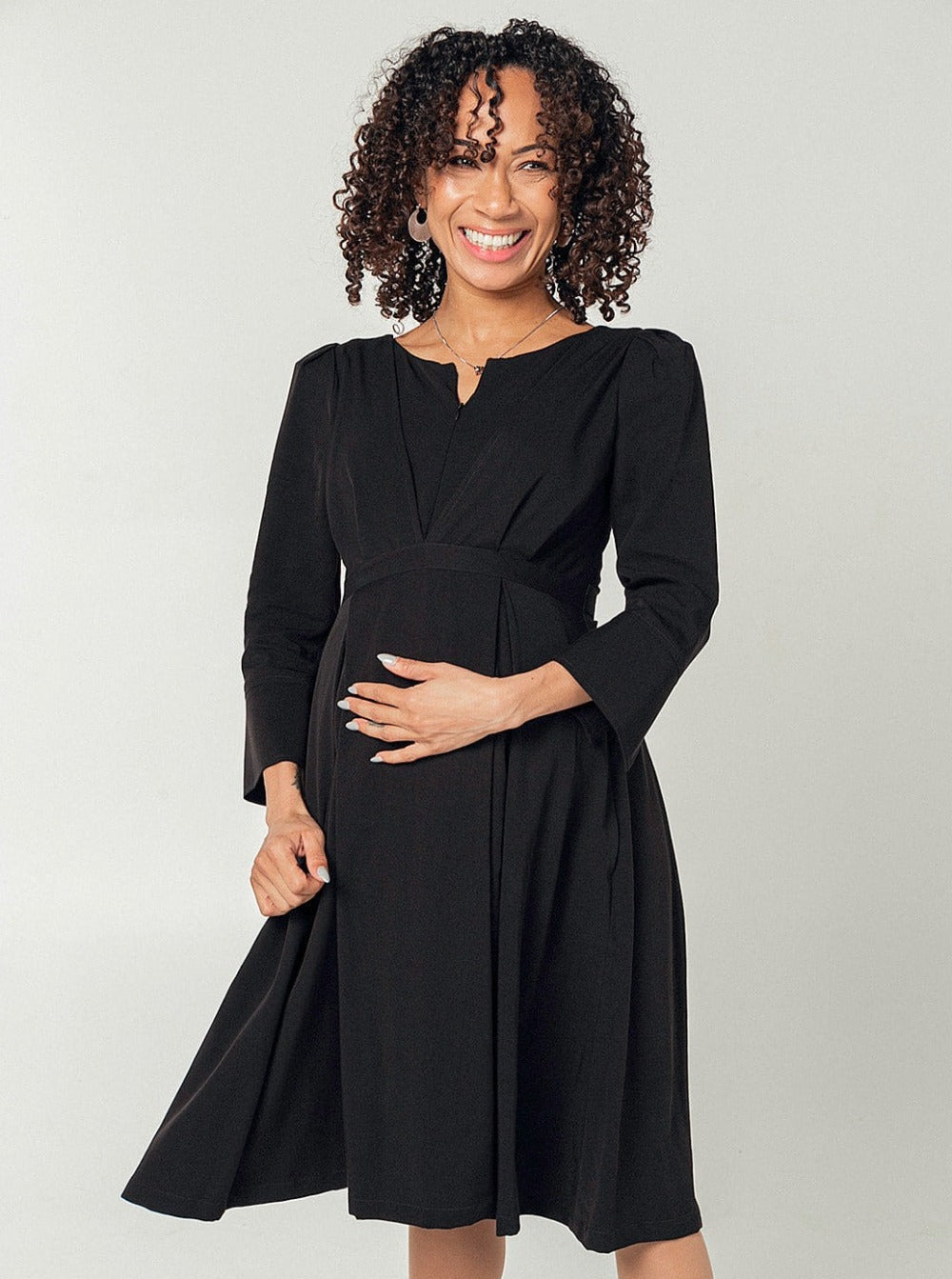 Black maternity and breastfeeding dress by MARION. Sustainable TENCEL empire waist style with deep pockets and full feminine skirt. Breastfeeding friendly with 3/4 sleeves and elegant cuff detail. Petite sizing also available.