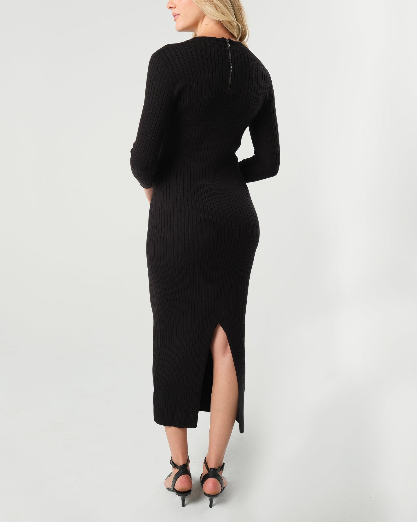 Woman wearing a high-end black long sleeve maxi sweater dress with flattering v neck by MARION. Luxury high stretch cotton knit fabric. Our best reviewed dress for holidays, parties, wedding guest outfits, and fall and winter weather comfort. 