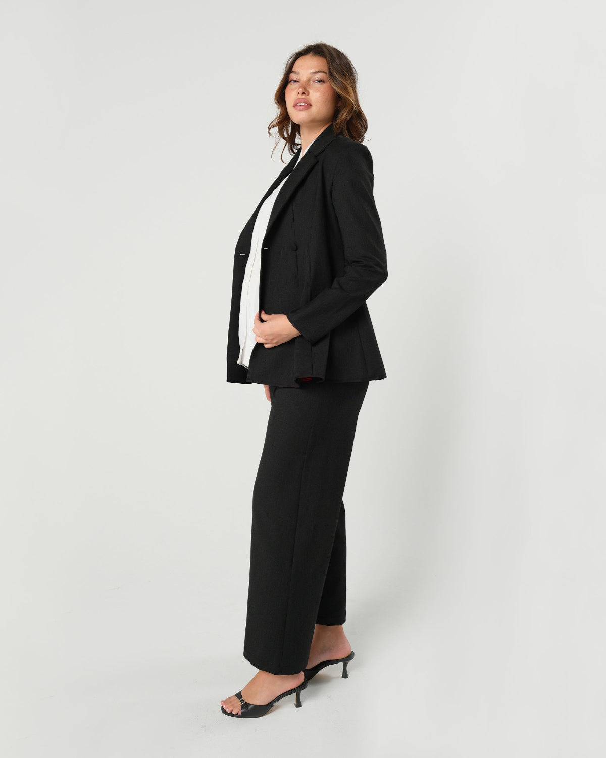 Black maternity wide leg dress pants for work with over belly band. Sustainable pregnancy business trousers cut with luxury Italian suiting fabric. Perfect maternity bottom separates for pregnancy pants suit.