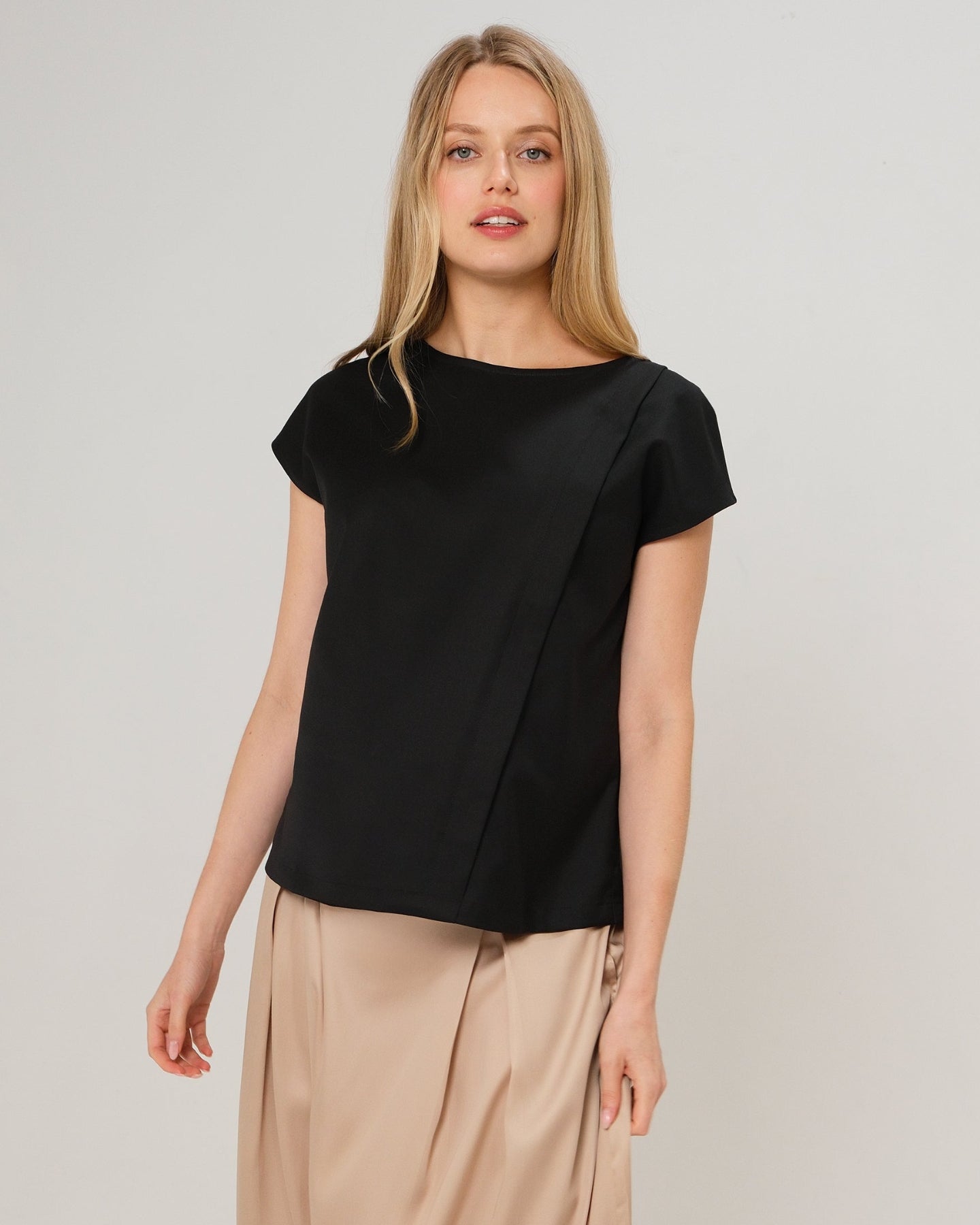 Black short sleeve designer maternity and nursing shell top in breathable tropical wool blend. This best - in - class pregnancy business attire or streetwear style with glowing parent expo reviews is sure to be one of the most sought after designs of 2026. Perfect for work, occasions, outings, and more, the cut is flattering and comfortable, with the diagonal zipper providing the perfect discreet breastfeeding zipper. Luxury pregnancy fashion by MARION.