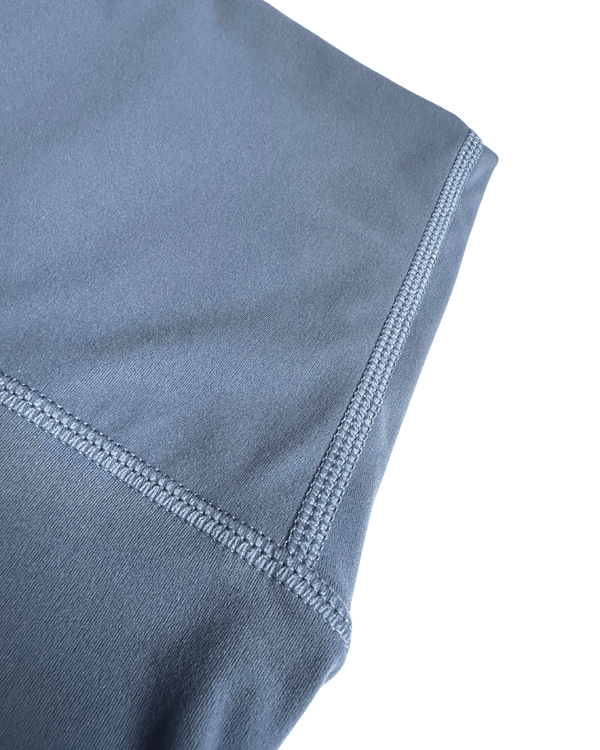 Close-up detail of premium blue maternity bike shorts showcasing reinforced flatlock stitching for durability and comfort, displayed on a white background. Premium maternity athletic and activewear by AXK.