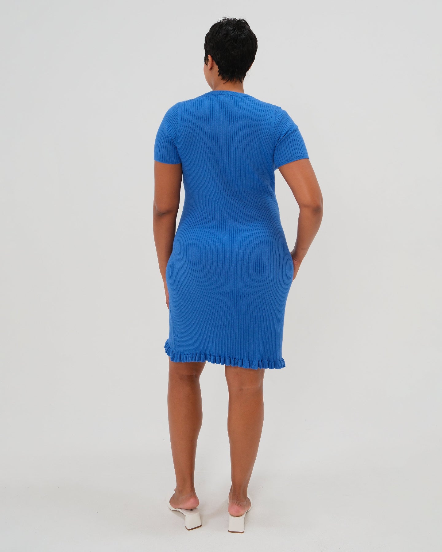 Plus size pregnant model wearing a high end vibrant blue knee length knit maternity dress. This dress features breathable luxury stretch cotton knit, a feminine hem ruffle, and easy crew neck. Garnering exceptional reviews, this best-in-class design is petite and tall friendly and offered in standard and plus sizes up to 2x. Perfect maternity business attire, wedding guest dress, party outfit, baby shower style, or casual street wear. 2026 MARION core season collection. 