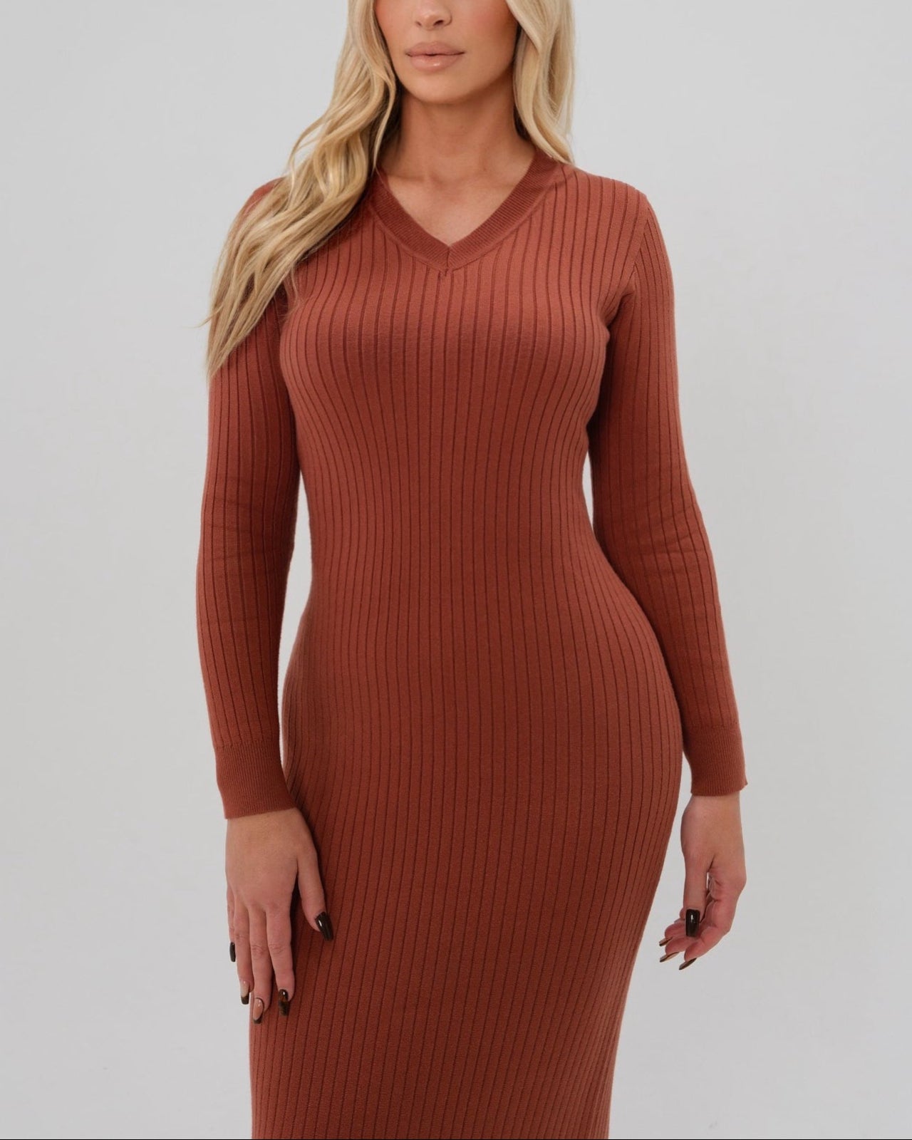 Woman wearing a high-end copper orange long sleeve maxi sweater dress with flattering v neck by MARION. Luxury high stretch cotton knit fabric, 2026 core collection. Our best reviewed dress in for holidays, parties, wedding guest outfits, and fall and winter weather comfort. 