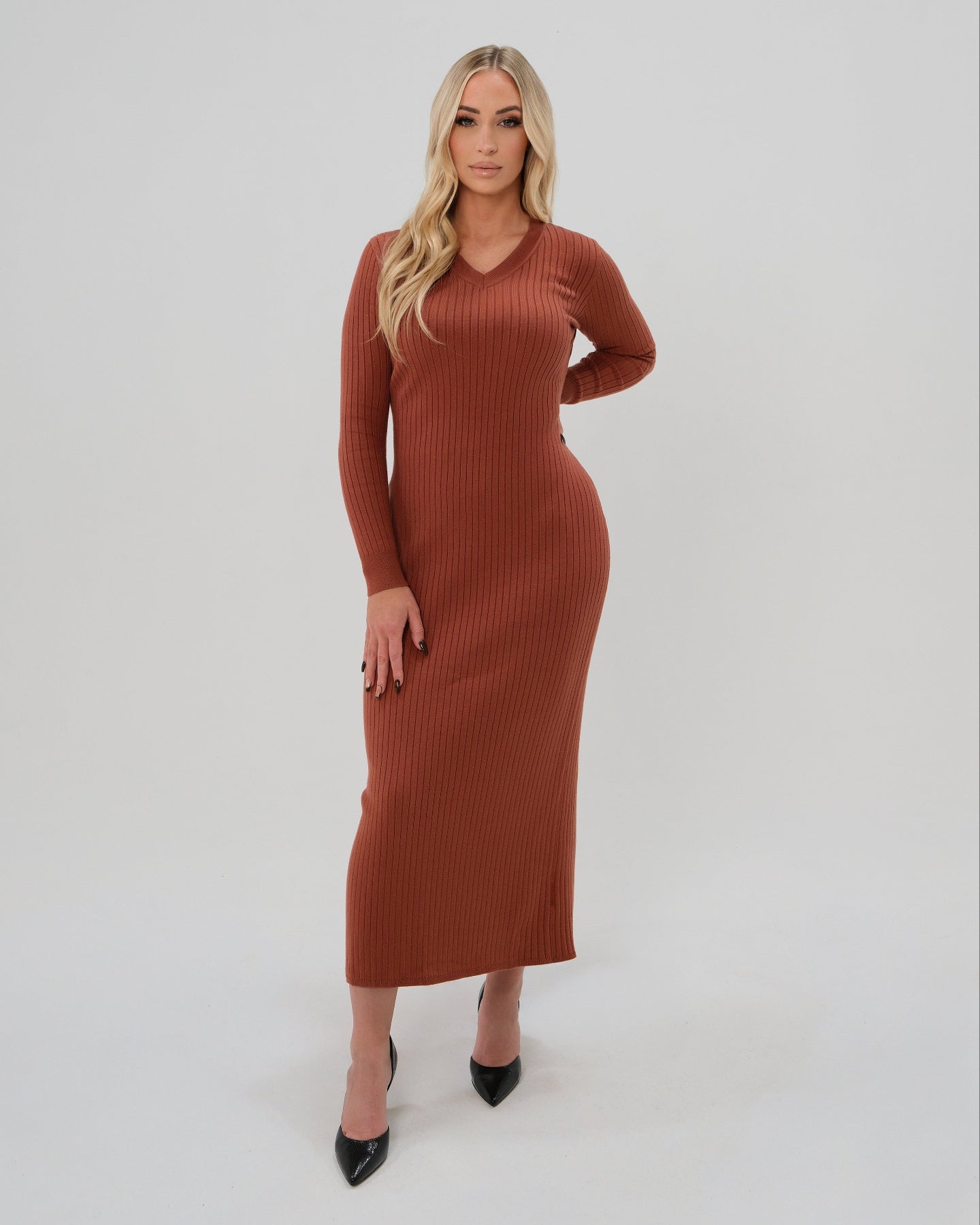 Woman wearing a high-end copper orange long sleeve maxi sweater dress with flattering v neck by MARION. Luxury high stretch cotton knit fabric. Our best reviewed dress for holidays, parties, wedding guest outfits, and fall and winter weather comfort. 