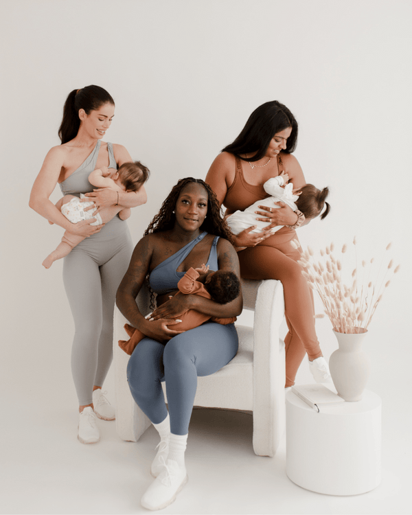 Three women wearing premium maternity leggings with supportive high waists and matching maternity and nursing sports bras in light gray, brown, and blue, each holding their babies in a studio with a white background and neutral decor. Premium maternity athletic and activewear by AXK.