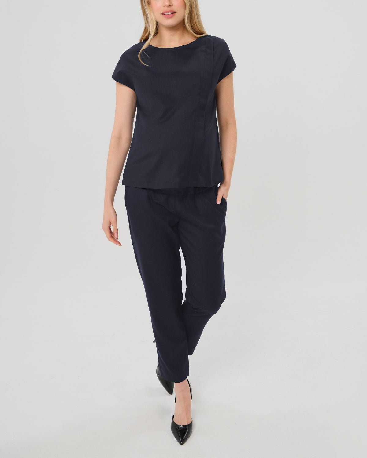 Navy maternity all-season wool blend under belly trousers with hidden flexible waist adjustment, deep pockets, and stylish straight leg. Pant cropped for tall mamas and full length for petite pregnant women. Postpartum friendly women's wear for business, wedding guest, dinner, and occasion. Front view.