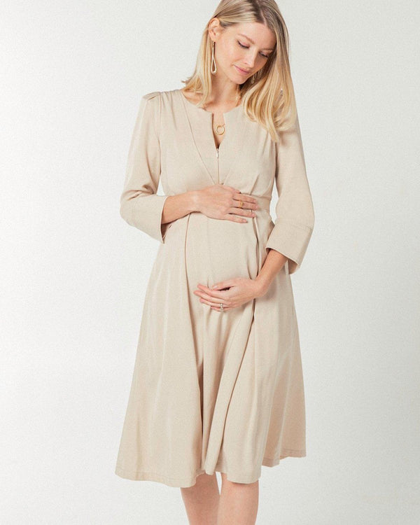 Beige maternity and nursing empire dress for business, baby shower, wedding guest, party, and formal occasions. Sustainable TENCEL, zipper breastfeeding access, and full skirt with deep pockets. Petite and standard sizes.