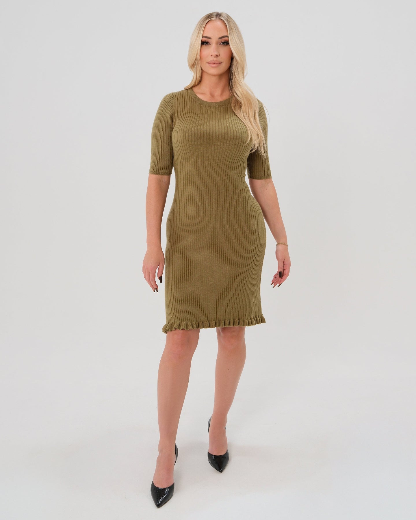 Premium olive green maternity sweater dress with 3/4 sleeves, feminine ruffle hem detail, and luxurious cotton stretch knit. This best in class design is perfect for work outfits, wedding guest, holiday parties, baby showers, and street style. Postpartum friendly. 2026 MARION core season collection. Worn by postpartum model.