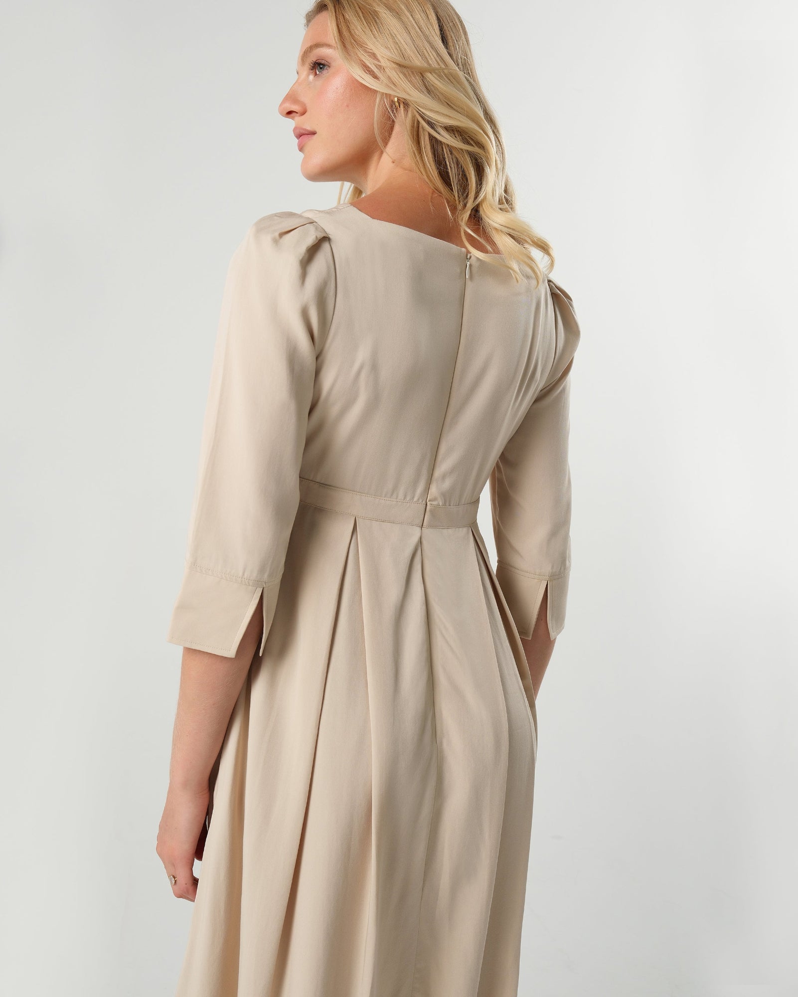 Beige maternity and nursing empire dress for business, baby shower, wedding guest, party, and formal occasions. Sustainable TENCEL, zipper breastfeeding access, and full skirt with deep pockets. MARION offers the market's best maternity dresses in petite and standard sizes.