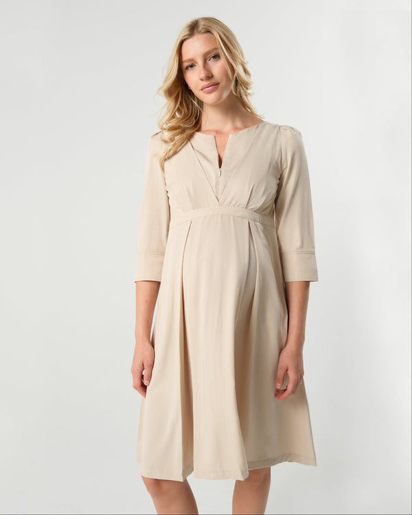 Beige maternity and nursing empire dress for business, baby shower, wedding guest, party, and formal occasions. Sustainable TENCEL, zipper breastfeeding access, and full skirt with deep pockets. MARION offers the market's best maternity dresses in petite and standard sizes.