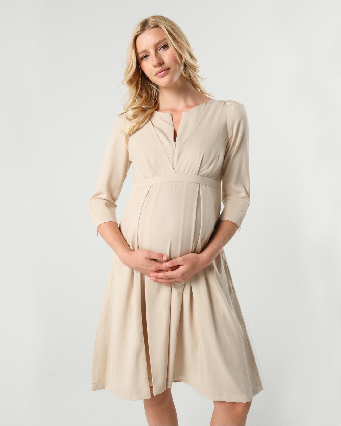 Best selling beige maternity and nursing empire dress for business, baby shower, wedding guest, party, and formal occasions boasting glowing 5-star reviews. Sustainable TENCEL, zipper breastfeeding access, and full skirt with deep pockets, the Sarah is a sure favorite in our 2026 core collection. 