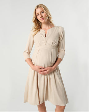 Beige maternity and nursing empire dress for business, baby shower, wedding guest, party, and formal occasions. Sustainable TENCEL, zipper breastfeeding access, and full skirt with deep pockets. MARION offers the market's best maternity dresses in petite and standard sizes.