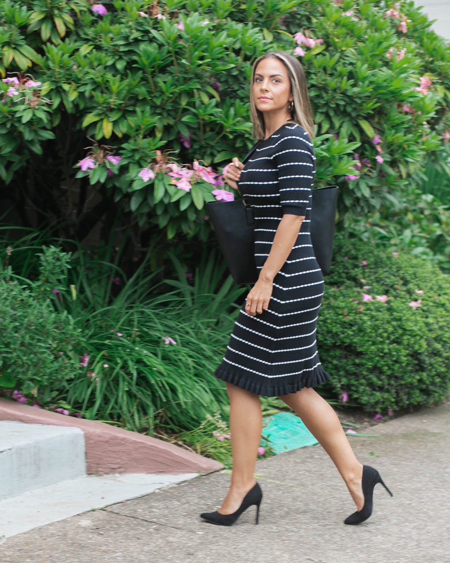 Petite postpartum model wearing bestselling knit maternity and nursing sweater dress in black &amp; white stripes. This knee length dress features three-quarter sleeves with a feminine hem detail and back zip for discreet breastfeeding access. Boasting countless 5-star reviews, this dress is ideal for maternity business wear, date night, church, wedding guest outfit, brunch, and occasion. For 2026, this style is petite and tall friendly, offered in regular and plus size. Available at Nordstrom, Bloomingdale&#39;s.