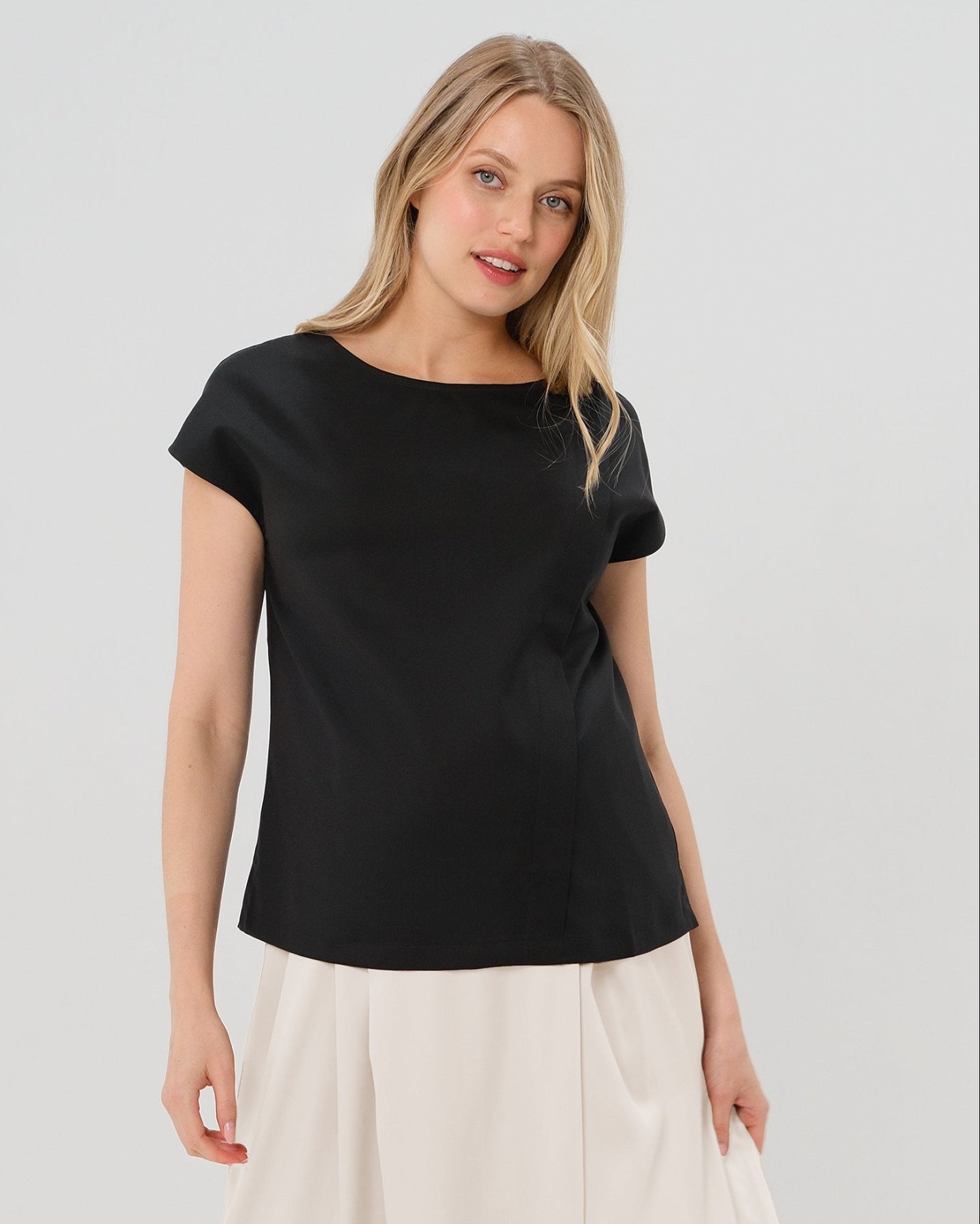 Black short sleeve designer maternity and nursing shell top in breathable tropical wool blend. This best - in - class pregnancy business attire or streetwear style with glowing parent expo reviews is sure to be one of the most sought after designs of 2026. Perfect for work, occasions, outings, and more, the cut is flattering and comfortable, with the diagonal zipper providing the perfect discreet breastfeeding zipper. Luxury pregnancy fashion by MARION.