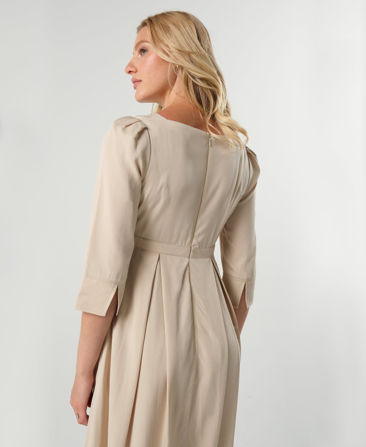 Beige maternity and nursing empire dress for business, baby shower, wedding guest, party, and formal occasions. Sustainable TENCEL, zipper breastfeeding access, and full skirt with deep pockets. Petite and standard sizes.