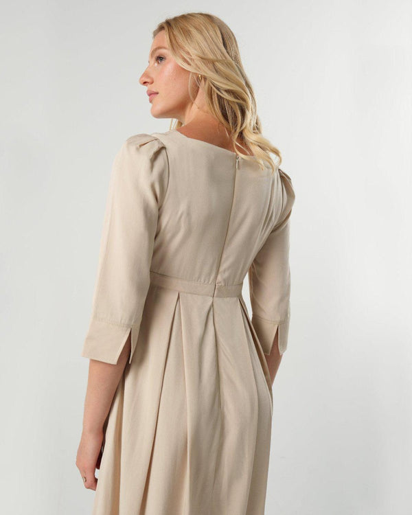 Beige maternity and nursing empire dress for business, baby shower, wedding guest, party, and formal occasions. Sustainable TENCEL, zipper breastfeeding access, and full skirt with deep pockets. Petite and standard sizes.