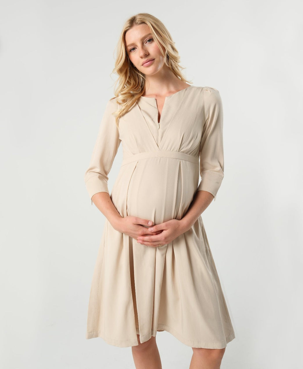 Beige maternity and nursing empire dress for business, baby shower, wedding guest, party, and formal occasions. Sustainable TENCEL, zipper breastfeeding access, and full skirt with deep pockets. Petite and standard sizes.