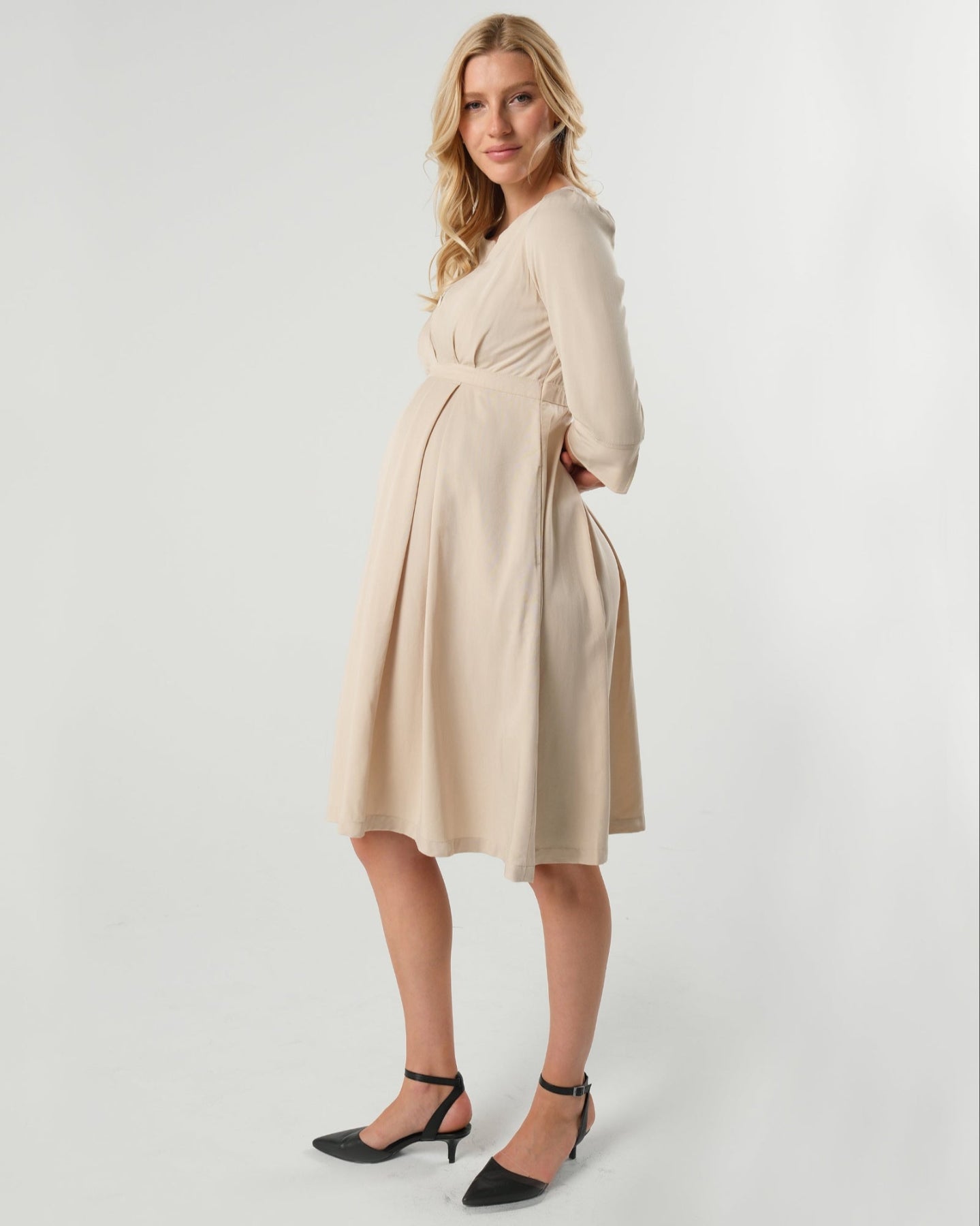 Best selling beige maternity and nursing empire dress for business, baby shower, wedding guest, party, and formal occasions boasting glowing 5-star reviews. Sustainable TENCEL, zipper breastfeeding access, and full skirt with deep pockets, the Sarah is a sure favorite in our 2026 core collection. 