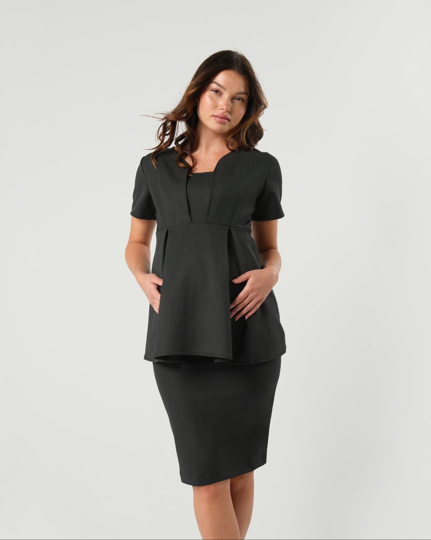 Charcoal gray premium maternity suit top separates, part of a corporate business maternity skirt or pant suit. This 5-star reviewed workwear top features nursing access for breastfeeding and pumping ease. The slimming and flattering Sloan blouse is cut with sustainable luxury Italian stretching suiting fabric, the Sloan is washable. Made for pregnant lawyers, executives, and even a business casual outfit. 