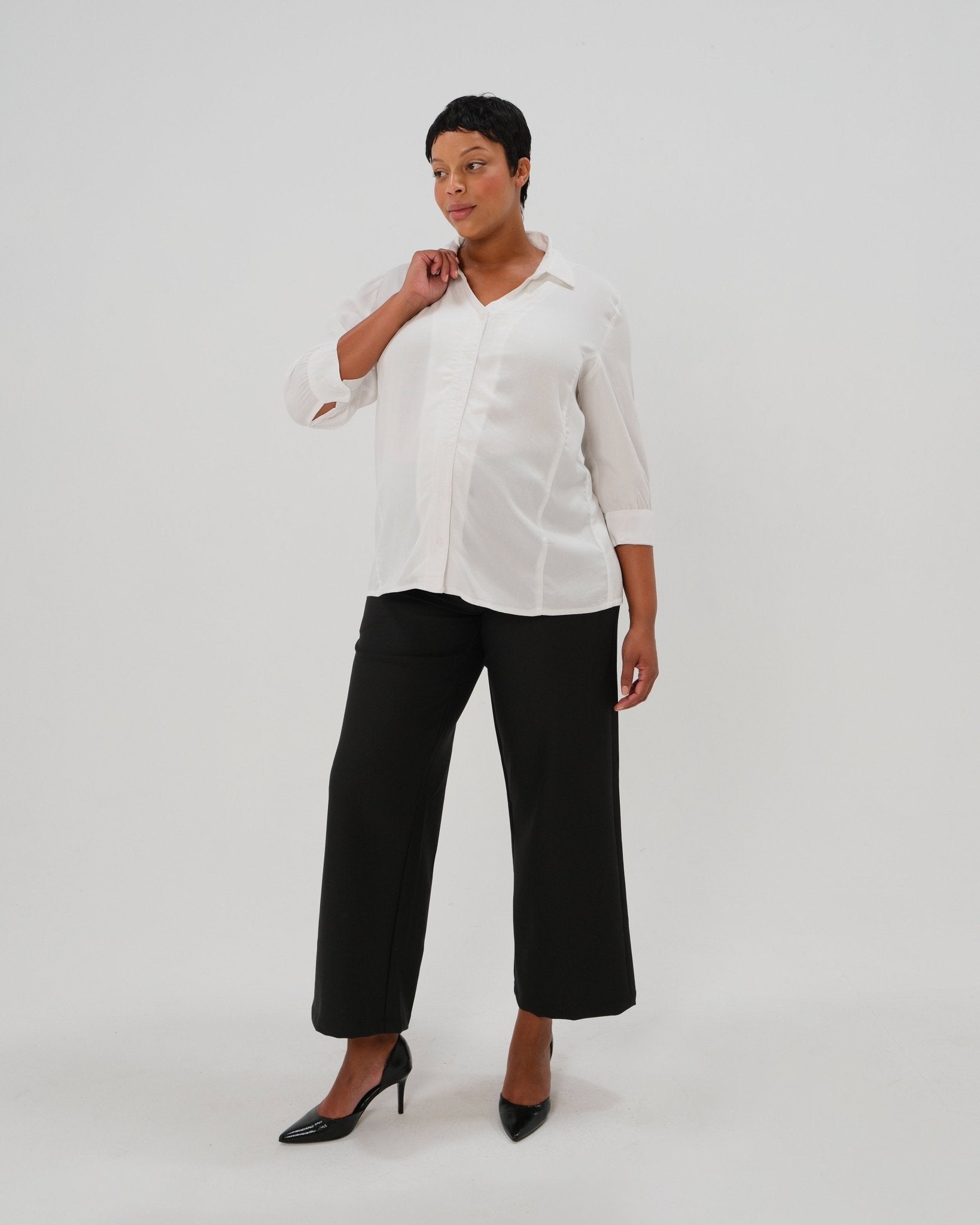 Plus size woman in maternity button down shirt for pregnancy and nursing by MARION with dozens of 5-star reviews. Maternity workwear top with no gap technology that prevents your bra from showing. Cut with luxury sustainable TENCEL, this classic blouse is the best possible choice for your business meeting at the office, the courtroom, or Saturday errands. For 2026, now available in petite sizes; made for pregnancy, nursing, postpartum, and womenswear. Sold by Nordstrom, Bloomingdale's, and Macy's.