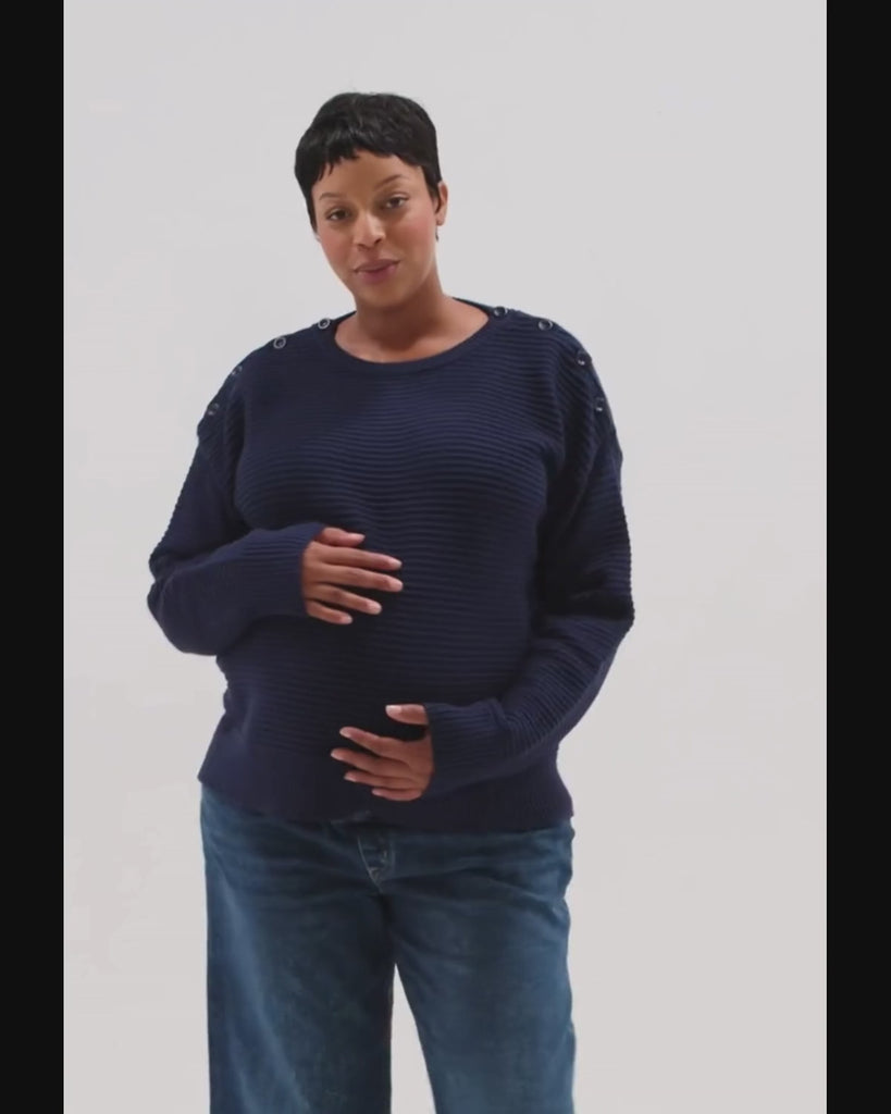 Video of pregnant woman wearing a navy blue premium maternity and nursing sweater in stretch cotton box knit. Featuring shoulder button detail for breastfeeding and discreet hem thumbholes for an extra cozy fit, our 5-star reviews for best maternity sweater are no surprise. This sweater's oversized fit is flattering, polished, and versatile - transitioning from pregnancy workwear to loungewear to streetwear with ease. Petite and tall friendly; available in regular and plus sizes in 2026. 